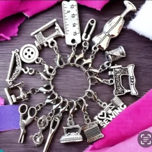 Sewing-themed charms on colorful fabric background.