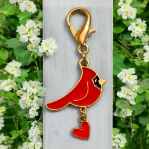 Red cardinal keychain with heart charm.