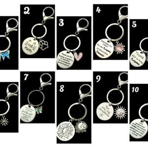 Ten keychains with engraved round pendants, each featuring different designs and quotes.