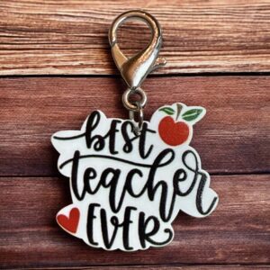 Keychain with 'Best Teacher Ever' text and decorative elements on wood background.