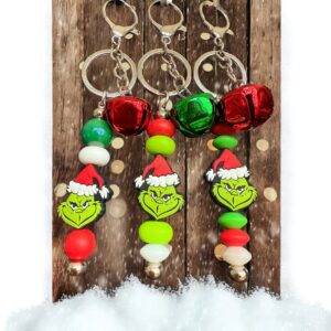 Festive Grinch-themed keychains with Santa hats and bells.
