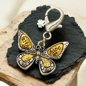 Butterfly keychain with words "faith," "trust," "hope," and "love" on its wings.