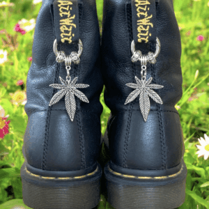 Black boots with cannabis leaf keychains and gold chain accents.