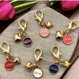 Colorful keychains with heart charms and 'Mom' tags on a wooden surface.
