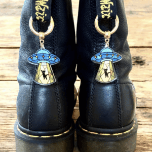 Black boots with blue mushroom keychains attached to the back.