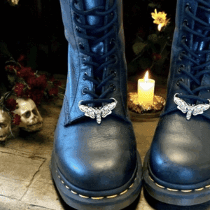 Blue boots with silver moth charms, surrounded by skulls and candles.