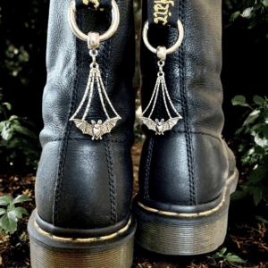 Close-up of black boots with unique chain decorations on the back.