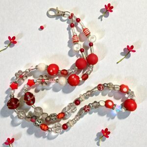 Elegant beaded necklace with red, white, and brown beads on a light background.