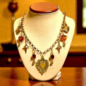 Elegant vintage necklace with ornate pendants and amber stones.