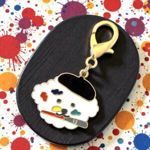 Cute cupcake keychain with colorful sprinkles on a black background.