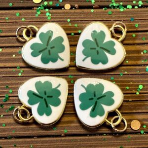 Heart-shaped cookies decorated with green four-leaf clovers for St. Patrick's Day.