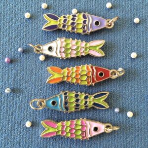 Colorful fish-shaped keychains on a blue fabric background.